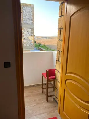 a room with a red chair and a window at Maison villa in Oulad Akkou