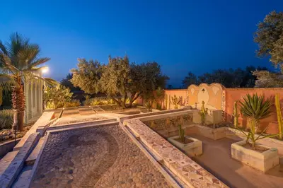 a swimming pool in a yard with trees and a fence at Havre de Paix à Marrakech in Heddad