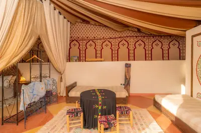 a room with a bed and a table and chairs at Havre de Paix à Marrakech in Heddad