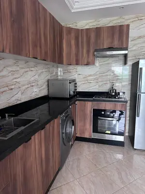 a kitchen with a stove and a refrigerator at Appartment propre in Oulad Akkou