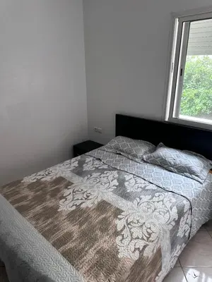 a bed in a bedroom with a window at Appartment propre in Oulad Akkou