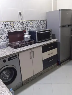 a kitchen with a stove and a microwave and a refrigerator at Residence de repos in Oulad Tayeb