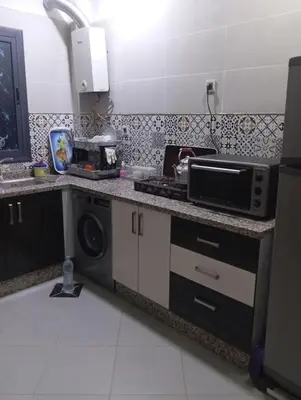 a kitchen with a stove and a microwave on a counter at Residence de repos in Oulad Tayeb