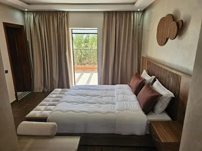 a bedroom with a large bed and a window at Villa des Perles in Marrakech