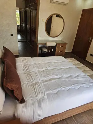 a bedroom with a large white bed with a mirror at Villa des Perles in Marrakech