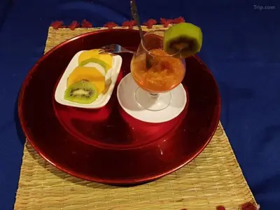 a red plate with a drink and a plate of food at Home khamlia in Merzouga
