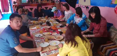 a group of people sitting around a table eating food at Home khamlia in Merzouga