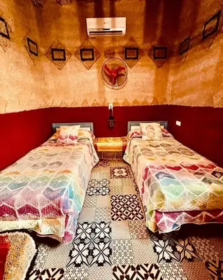 two beds sitting next to each other in a room at Home khamlia in Merzouga