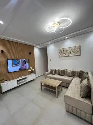 a living room with a couch and a tv at Appartement in Oulad Akkou