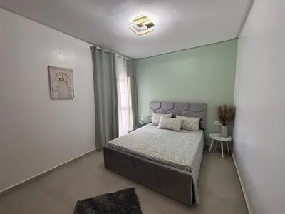 a bedroom with a large bed and a window at Appartement in Oulad Akkou
