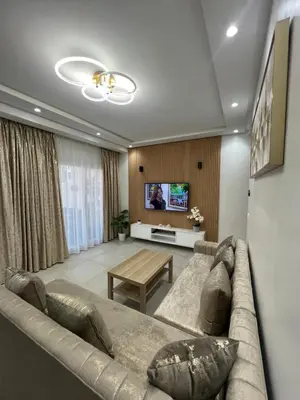 a living room with a couch and a tv at Appartement in Oulad Akkou