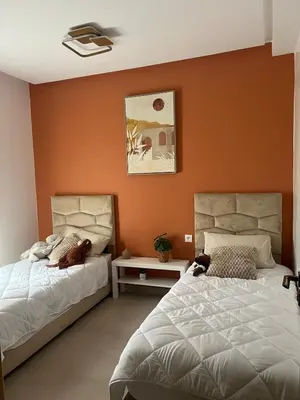 two beds sitting next to each other in a bedroom at Appartement in Oulad Akkou