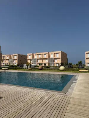 a swimming pool in front of some apartment buildings at luxurious Taghazout duplex in Oulad Akkou