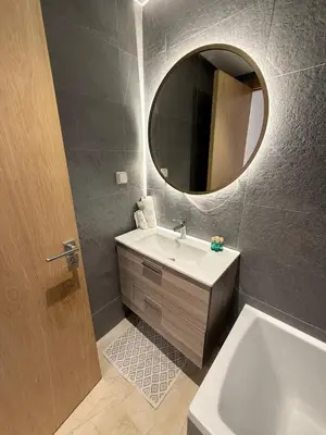 a bathroom with a sink and a mirror and a tub at luxurious Taghazout duplex in Oulad Akkou