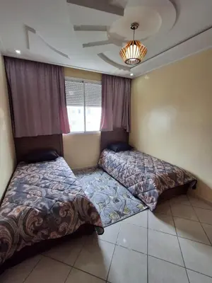 a bedroom with two beds and a window at yas appart in Oulad Akkou