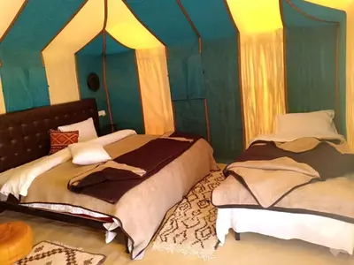 a bedroom with two beds in a room at lina safari luxury camp in Merzouga