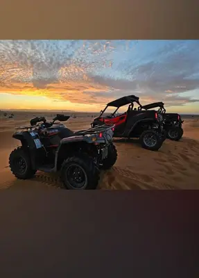 two atvs parked on the beach at sunset at lina safari luxury camp in Merzouga