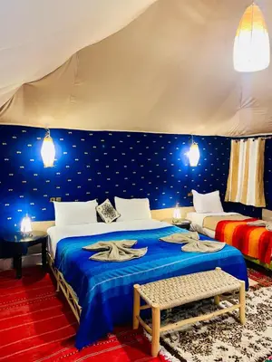 a bedroom with two beds in a tent at lina safari luxury camp in Merzouga