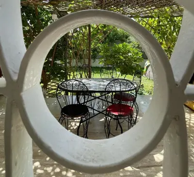 a table with chairs and a table with a circular window at dar marwa in Fès