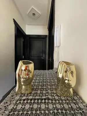 two gold vases sitting on top of a bed at dar marwa in Fès