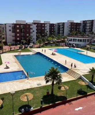 a large swimming pool with people standing around it at Complexe OCEAN ATLANITIQUE in Oulad Akkou