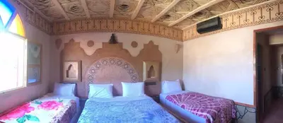 a bedroom with two beds and a ceiling at Hotel KASBAH DADES MGOUN in Kalaat MGouna