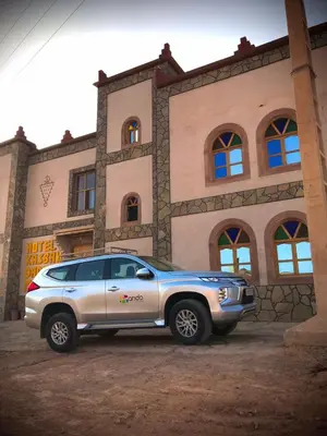 a silver suv parked in front of a building at Hotel KASBAH DADES MGOUN in Kalaat MGouna