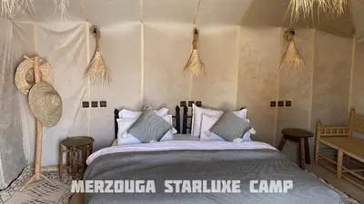 a bedroom with a bed in a tent at Merzouga Starluxe Camp in Merzouga