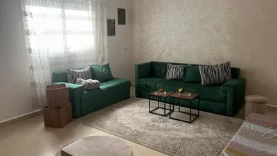 a living room with a green couch and a table at cozy stay in Oulad Akkou