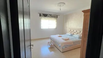 a bedroom with a bed with blue pillows and a window at cozy stay in Oulad Akkou