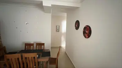 a dining room with a table and a clock on the wall at cozy stay in Oulad Akkou