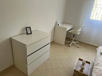 a bedroom with a dresser and a desk and a chair at cozy stay in Oulad Akkou