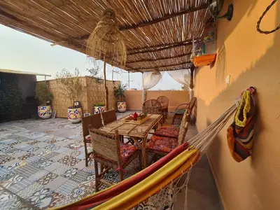 a patio with a table and chairs and an umbrella at House Silya in Oulad Akkou