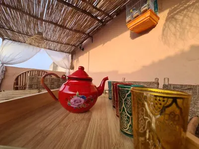 a red tea pot sitting on top of a table at House Silya in Oulad Akkou