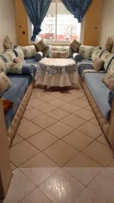 a living room with a long couch and a window at Appartement à Agadir in Azrou