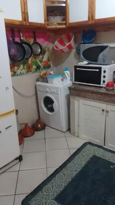 a kitchen with a microwave and a washing machine at Appartement à Agadir in Azrou