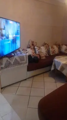 a living room with a couch with a flat screen tv at Appartement à Agadir in Azrou