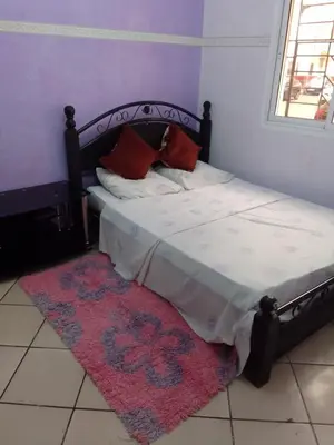 a bedroom with a bed with a rug on the floor at Appartement à Agadir in Azrou