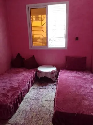 a pink room with two beds and a window at Appartement à Agadir in Azrou