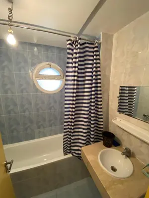 a bathroom with a sink and a tub and a window at Facing the sea, close to the Corniche in Oulad Akkou