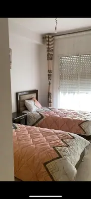 a bedroom with two beds and a window at Facing the sea, close to the Corniche in Oulad Akkou