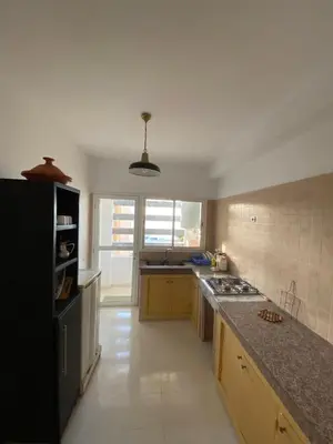 a kitchen with a counter and a stove top oven at Facing the sea, close to the Corniche in Oulad Akkou