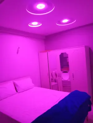 a bedroom with a bed with purple lights on it at Kinan in Fès