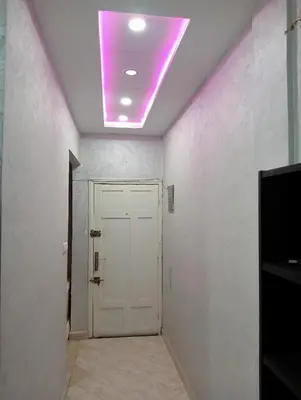 a hallway with a white door and a purple light at Kinan in Fès