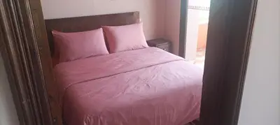 a bed with pink sheets and pillows in a room at Marrakech Le Joyau de l'ourika in Ourika