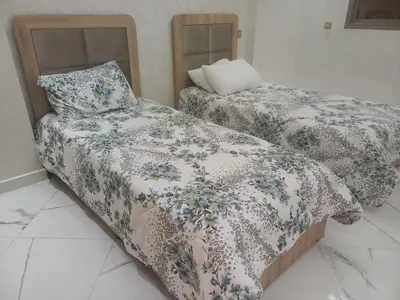 two beds with blankets and pillows in a room at JOLIE APPART à BOUZNIKA in Oulad Akkou