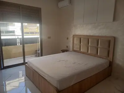 a bedroom with a bed and a large window at JOLIE APPART à BOUZNIKA in Oulad Akkou