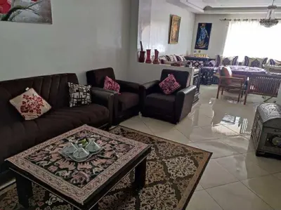 a living room with couches and a coffee table at Appartement de vacances in Oulad Akkou