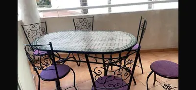 a table and four chairs and a table and a window at Appartement de vacances in Oulad Akkou