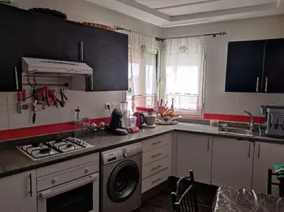 a kitchen with a stove and a washing machine at Appartement de vacances in Oulad Akkou